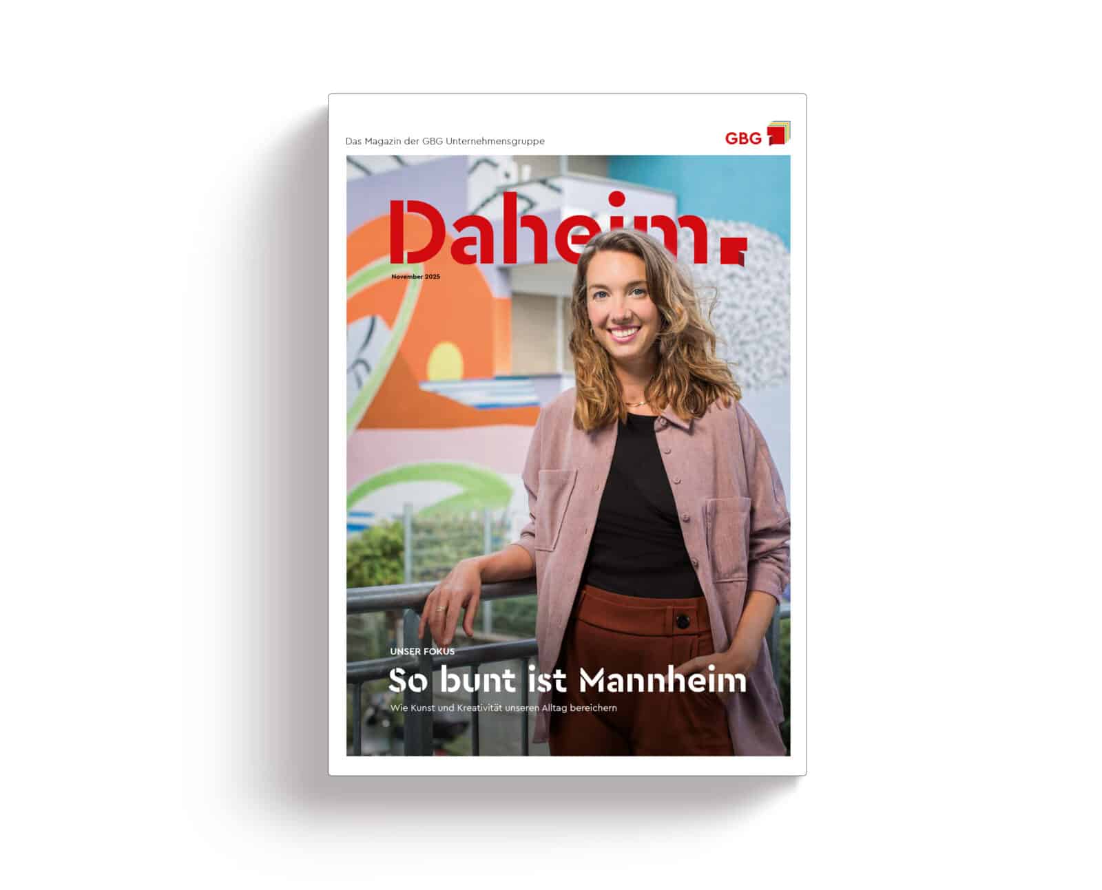 KI-basierte Bildbeschreibung | Eine Frau steht lächelnd vor einem farbenfrohen Wandgemälde, das auf der Titelseite des Magazins Daheim mit der Schlagzeile So bunt ist Mannheim abgebildet ist.